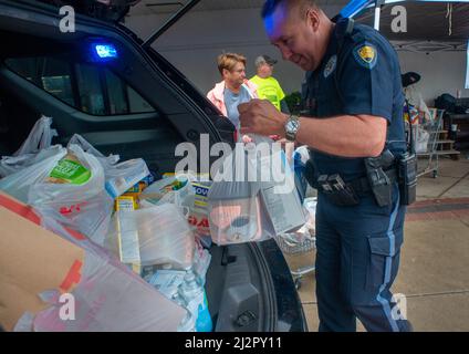 Warminster, Usa. 03. April 2022. Chris McCole, Polizeibeamter von Warminster (rechts), hilft Linda Morrow bei der Einladung von Spenden in das Polizeiauto während einer Fahrt mit Lebensmitteln, um die Lebensmittelregale der Warminster Food Bank am Sonntag, den 03. April 2022 bei Giant in Warminster, Pennsylvania, aufzufüllen. Über 2300 Pfund Lebensmittel wurden zusammen mit Geschenkkarten und anderen Gegenständen gespendet. (Foto: William Thomas Cain/Alamy Live News Stockfoto
