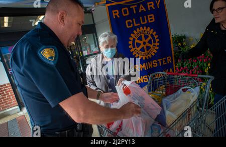 Warminster, Usa. 03. April 2022. Chris McCole, Polizeibeamter von Warminster (links), hilft bei Spenden während einer Lebensmittelaktion, um die Lebensmittelregale der Warminster Food Bank am Sonntag, den 03. April 2022 in Gant in Warminster, Pennsylvania, aufzufüllen. Über 2300 Pfund Lebensmittel wurden zusammen mit Geschenkkarten und anderen Gegenständen gespendet. (Foto: William Thomas Cain/Alamy Live News Stockfoto