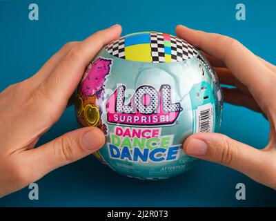 Tambow, Russische Föderation - 29. März 2022 Frau Hände halten die LOL Surprise Dance Dance Dance Ball mit Puppe. Blauer Hintergrund. Stockfoto