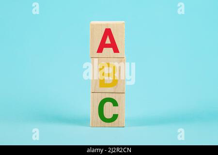 ABC auf Holzblöcken. ABC Buchstaben Alphabet auf Holzwürfelblöcken in Säulenform auf blauem Hintergrund. Fremdsprachen lernen. Englisch für Anfänger Stockfoto