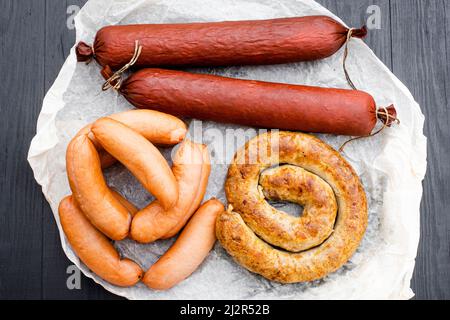 Verschiedene Arten von Naturwürsten auf einem hölzernen Hintergrund. Stockfoto