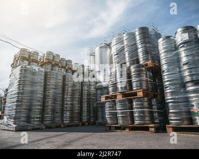 Bierkegs. Viele Metallfässer oder Behälter für Brauereien in Paletten im Freien gestapelt. Stockfoto