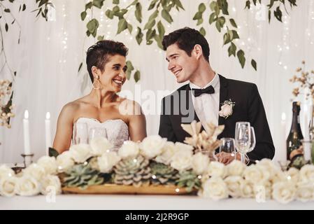 Ich kann es kaum erwarten, hier zu verharren. Aufnahme eines jungen Paares, das bei ihrem Hochzeitsempfang zusammen sitzt. Stockfoto