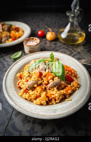 Bulgur mit Hühnerherzen und Gemüse. Köstliches gesundes Gericht auf dunklem Hintergrund, Draufsicht. Bulgur Pilaf Stockfoto