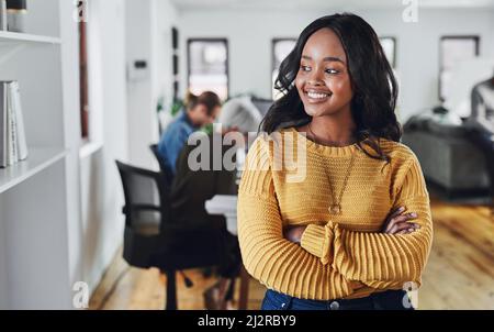 Shes denken positive Gedanken. Ausgeschnittene Aufnahme einer attraktiven jungen Geschäftsfrau, die nachdenklich aussieht, während sie mit eingeklappten Armen im Stehen steht Stockfoto