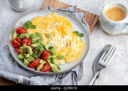 Rührei mit Kirschtomaten und Avocado Stockfoto
