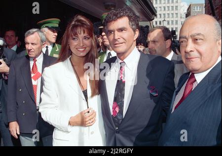 Der amerikanische Schauspieler Burt Reynolds eröffnet den Harrods Sale. Abgebildet mit Miss UK Claire Smith und Harrods Besitzer Mohamed Al-Fayed. 7.. Juli 1993. Stockfoto