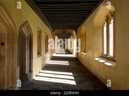 Der historische Kreuzgang, auch bekannt als der große Quad, am Magdalen College, University of Oxford UK. Durch das gotische Bogenfenster strömt Sonnenlicht hinein Stockfoto