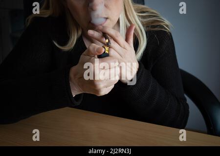 Frau zündete ihre Zigarillo mit Zigarettenanzünder an Stockfoto