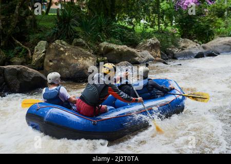 Die Natur bietet einige der besten Abenteuer. Aufnahme einer Gruppe von jungen männlichen Freunden Wildwasser-Rafting. Stockfoto