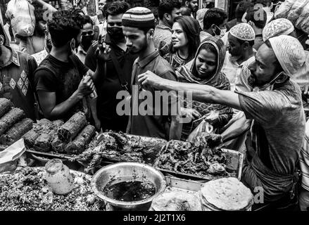 Einwohner von Bangladesch verkaufen Iftar-Gegenstände am ersten Tag des muslimischen Fastenmonats Holly Ramadan auf dem Chawkbazar in der Hauptstadt Dhaka, Bangladesch Stockfoto