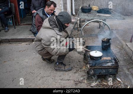 Mariupol, Ukraine. 03. April 2022. Die Bewohner kochen auf einem provisorischen Herd, der von verbrauchten Panzerschalen aufgestacheln wird. Der Kampf zwischen Russland und der Ukraine unter der Führung des Asow-Bataillons wird in der Hafenstadt Mariupol fortgesetzt. Kredit: SOPA Images Limited/Alamy Live Nachrichten Stockfoto