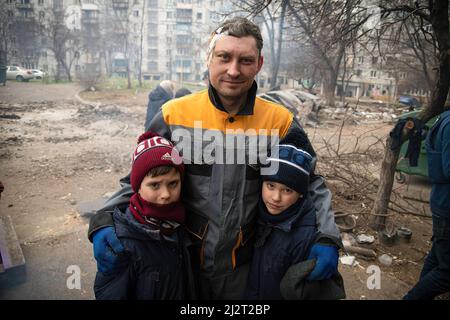 Mariupol, Ukraine. 03. April 2022. Ein verwundeter Mann steht mit seinen Kindern in einer Nachbarschaft, die durch den Ukraine-russischen Krieg zerstört wurde. Der Kampf zwischen Russland und der Ukraine unter der Führung des Asow-Bataillons wird in der Hafenstadt Mariupol fortgesetzt. Kredit: SOPA Images Limited/Alamy Live Nachrichten Stockfoto