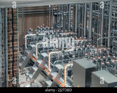 Moderne automatisierte Maschinenausrüstung in der kleinen handwerklichen Brauerei. Stahlrohre und Tanks in der Getränksproduktion Herstellung. Stockfoto