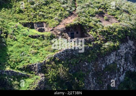 Alte Steinhöhlenhäuser, die in einer Felswand in der Nähe des Dorfes Taborno in den Anaga-Bergen von Teneriffa, Anaga Rural Park, Kanarische Inseln, Spanien, begraben sind. Stockfoto