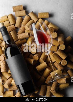 Festliche Komposition. Auf den Weinkorken befindet sich eine Flasche Rotwein und ein Glas. Nahaufnahme. Auf dem Foto befinden sich keine Personen. Weinsammlung, Weinberg, Wein ce Stockfoto