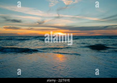 Landschaftlich schöne Meereslandschaft, Sonnenuntergang über dem Meer. Die ruhige Szene, die wunderschöne Sonnenreflexion und die stürmischen Wellen des Ozeans Stockfoto