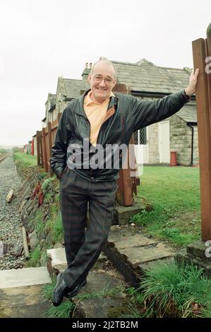 Jim Bowen bei der Eisenbahn, die an seinem Haus in Arkholme, Lancashire, vorbeifährt. 9.. April 1993. Stockfoto