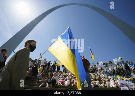 St. Louis, Usa. 03. April 2022. Michael Leontilee hält am Sonntag, den 3. April 2022, eine ukrainische Flagge auf den Stufen des Gateway Arch in St. Louis. Die ukrainische Gemeinschaft versammelte sich am Bogen mit gespendeten Stofftieren, die die Hunderte von Kindern darstellen, die während der aktuellen russischen Invasion getötet wurden. Die Versammlung umfasste Worte der Ermutigung, Gebete und ukrainische Musik. Foto von Bill Greenblatt/UPI Credit: UPI/Alamy Live News Stockfoto