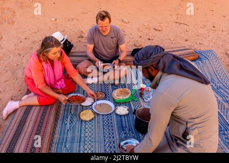 Besucher von Wadi Rum genießen Ein Beduinenessen, Wadi Rum, Jordanien, Asien. Stockfoto