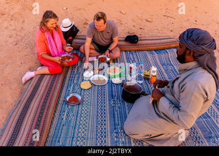Besucher von Wadi Rum genießen Ein Beduinenessen, Wadi Rum, Jordanien, Asien. Stockfoto