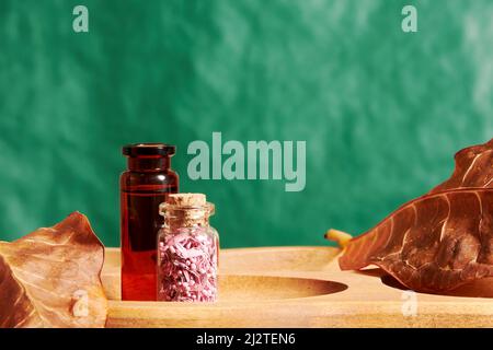 Haarwasser und Glas mit duftenden Blütenblättern auf dem Tablett im Kosmetikgeschäft. Schönheit und Mode Hintergründe und Produkte Stockfoto