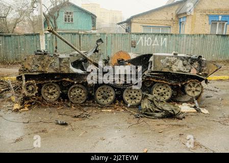 Kiew, Ukraine. 03. April 2022. Ein zerstörter russischer APC befindet sich in einer Straße in Bucha, einem Vorort der Hauptstadt Kiew. Während sich russische Truppen aus Gebieten nördlich der ukrainischen Hauptstadt Kiew zurückziehen, nennen ukrainische Beamte die schweren zivilen Opfer, die in der Stadt Bucha tot aufgefunden wurden, ein vorsätzliches Kriegsverbrechen, was die Internationale Verurteilung auslöste. Kredit: SOPA Images Limited/Alamy Live Nachrichten Stockfoto