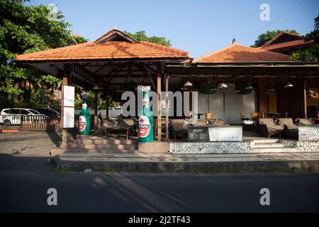 Jalan Kartika Plaza in Kuta, Bali mit der berühmten Kabar Grill Bintang Bierflasche auf der linken Seite. Stockfoto