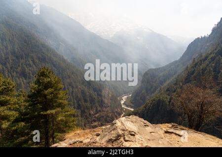 Ein Aussichtspunkt mit Blick auf ein rauchgefülltes Tal auf dem Trek zum Everest Base Camp. Stockfoto