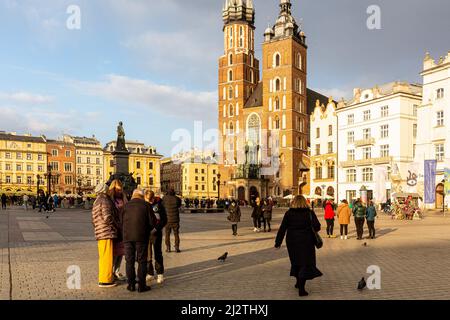 Krakau, Polen. 03. April 2022. Eine ukrainische Familie geht auf dem Hauptmarkt in Krakau spazieren, da die meisten Besucher dieser UNESCO-Stätte nun Ukrainer sind. Der Konflikt zwischen der Ukraine und Russland wird voraussichtlich bis zu 5 Millionen Ukrainer zur Flucht zwingen. Viele der Flüchtlinge suchen in Polen Asyl. Die meisten karitativen Hilfen in Polen werden von Einzelpersonen, NGOs und Unternehmen geleistet. Nach einem Monat des Konflikts sucht Polen nach Möglichkeiten, ukrainische Flüchtlinge zu integrieren und Polen und Ukrainern Raum für Kontakt und Zusammenarbeit zu bieten. Kredit: SOPA Images Limited/Alamy Live Nachrichten Stockfoto