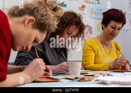 Krakau, Polen. 03. April 2022. Frauen besuchen ukrainische Folklore dekorieren Workshop von ukrainischen Flüchtling, Lolita Igorivna im Galicja Jüdischen Museum. Der Konflikt zwischen der Ukraine und Russland wird voraussichtlich bis zu 5 Millionen Ukrainer zur Flucht zwingen. Viele der Flüchtlinge suchen in Polen Asyl. Die meisten karitativen Hilfen in Polen werden von Einzelpersonen, NGOs und Unternehmen geleistet. Nach einem Monat des Konflikts sucht Polen nach Möglichkeiten, ukrainische Flüchtlinge zu integrieren und Polen und Ukrainern Raum für Kontakt und Zusammenarbeit zu bieten. Kredit: SOPA Images Limited/Alamy Live Nachrichten Stockfoto