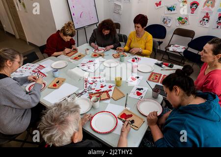 Krakau, Polen. 03. April 2022. Frauen besuchen ukrainische Folklore dekorieren Workshop von ukrainischen Flüchtling, Lolita Igorivna im Galicja Jüdischen Museum. Der Konflikt zwischen der Ukraine und Russland wird voraussichtlich bis zu 5 Millionen Ukrainer zur Flucht zwingen. Viele der Flüchtlinge suchen in Polen Asyl. Die meisten karitativen Hilfen in Polen werden von Einzelpersonen, NGOs und Unternehmen geleistet. Nach einem Monat des Konflikts sucht Polen nach Möglichkeiten, ukrainische Flüchtlinge zu integrieren und Polen und Ukrainern Raum für Kontakt und Zusammenarbeit zu bieten. Kredit: SOPA Images Limited/Alamy Live Nachrichten Stockfoto