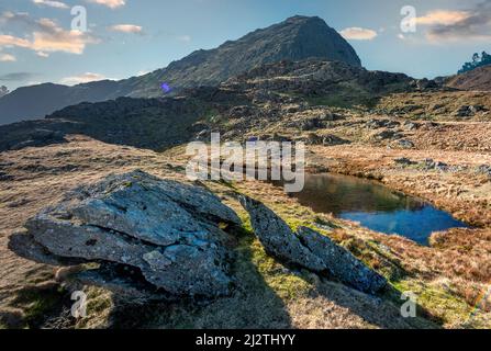 Snowdonia National Park, sonniges Wetter Mitte März, Blick auf den Mount Snowdon Gipfel vom Watkin Path aus, in die grelle direkte Sonneneinstrahlung, spät ein Stockfoto