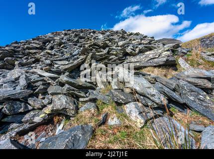 Schiefersteinbruch entlang des Watkin-Wanderweges, der zum Snowdon-Gipfel führt, an einem klaren, sonnigen Nachmittag Mitte März, einer von vielen Schieferhügeln, die auf dem Land gefunden werden Stockfoto