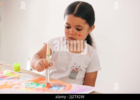 Ermutigen Sie Ihre Kinder, kreativ zu sein. Aufnahme eines entzückenden kleinen Mädchens, das an einem Tisch sitzt. Stockfoto