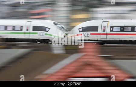 31. März 2022, Hessen, Frankfurt/Main: Ein ICE der Deutschen Bahn, an dem zwei Triebwagen befestigt sind, fährt auf einer erhöhten Schiene am Frankfurter Hauptbahnhof (Foto mit längerer Verschlusszeit und Zugfahrt). Den öffentlichen Nahverkehr fit für die Zukunft machen - das ist das Ziel des "Intensiven Eisenbahnprogramms", an dem das Land Hessen, der Rhein-Main-Verkehrsverbund (RMV) und die Deutsche Bahn (DB) beteiligt sind. Am 4. April 2022 geben die drei Partner einen Überblick über aktuelle Projekte in der Rhein-Main-Region. Sie wollen erklären, was in den letzten Jahren bereits umgesetzt wurde Stockfoto