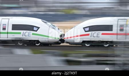 31. März 2022, Hessen, Frankfurt/Main: Ein ICE der Deutschen Bahn, an dem zwei Triebwagen befestigt sind, fährt auf einer erhöhten Schiene am Frankfurter Hauptbahnhof (Foto mit längerer Verschlusszeit und Zugfahrt). Den öffentlichen Nahverkehr fit für die Zukunft machen - das ist das Ziel des "Intensiven Eisenbahnprogramms", an dem das Land Hessen, der Rhein-Main-Verkehrsverbund (RMV) und die Deutsche Bahn (DB) beteiligt sind. Am 4. April 2022 geben die drei Partner einen Überblick über aktuelle Projekte in der Rhein-Main-Region. Sie wollen erklären, was bereits in recen umgesetzt wurde Stockfoto