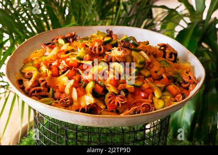 Gegrillter marinierter Seafood-Salat mit Garnelen, Oktopus, Tintenfischen, Brokkoli und Salatblättern Stockfoto