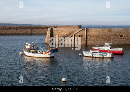 Kleines Fischerboot in einem bretonischen Hafen mit bunten Schwimmern und Fangfallen und Netzen Stockfoto