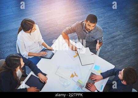Präsentation unserer Kampagne vor einem Kunden. Eine Aufnahme einer Gruppe junger Geschäftsleute, die bei der Arbeit an einem Sitzungssaal zusammentreffen. Stockfoto