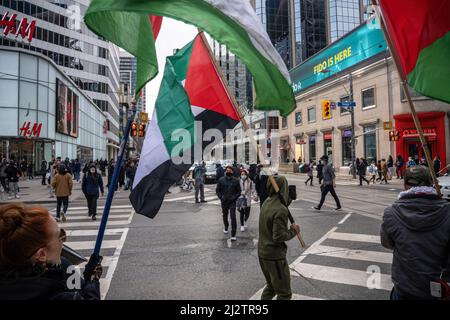 Toronto, Kanada. 02. April 2022. Während der Kundgebung schwenken die Demonstranten auf einem Fußgängerüberweg palästinensische Fahnen. Demonstranten versammelten sich auf dem Yonge-Dundas-Platz in Toronto, Kanada, in Solidarität mit Palästina. Kredit: SOPA Images Limited/Alamy Live Nachrichten Stockfoto