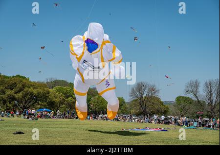 Austin, Texas, USA. 3. April 2022. Go Big oder Go Home Kite Flying Organisation startet einen Astronauten mit einem anderen Drachen zu helfen, es zu heben. Das ABC Kite Festival 93. kehrte am Sonntag in den Zilker Park zurück. Tausende von Besuchern flogen bunte Drachen über den 350 Hektar großen Park. Kredit: Sidney Bruere/Alamy Live Nachrichten Stockfoto