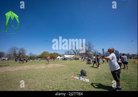 Austin, Texas, USA. 3. April 2022. Mark, 50, aus Austin tut sein Bestes, um seinen leuchtend grünen Drachen in die Luft zu bringen. Er arbeitet am See und sagt, dass man nur den Drachen an der Rückseite des Bootes binden muss und er fliegt. Das ABC Kite Festival 93. kehrte am Sonntag in den Zilker Park zurück. Tausende von Besuchern flogen bunte Drachen über den 350 Hektar großen Park. Kredit: Sidney Bruere/Alamy Live Nachrichten Stockfoto