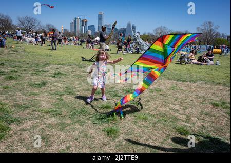 Austin, Texas, USA. 3. April 2022. Layla, die gerade 4 Jahre alt ist, aus Austin, hat eine tolle Zeit mit ihrem bunten Drachen. Das ABC Kite Festival 93. kehrte am Sonntag in den Zilker Park zurück. Tausende von Besuchern flogen bunte Drachen über den 350 Hektar großen Park. Kredit: Sidney Bruere/Alamy Live Nachrichten Stockfoto