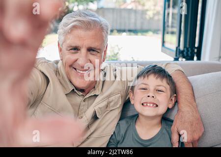 Es gibt keinen Ort wie zu Hause, außer bei den Großvätern. Aufnahme eines entzückenden kleinen Jungen, der zu Hause Selfies mit seinem Großvater macht. Stockfoto