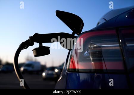 Aktenfoto vom 08//03/22 eines Tesla-Elektrofahrzeugs, das in Hayes, West-London, geladen wird. Mehr als sieben von 10 britischen Räten haben keine Übergangspläne für Elektrofahrzeuge (EV) veröffentlicht, obwohl sie von der Regierung dazu ermutigt wurden. Antworten auf Informationsfreiheitsanfragen der FairCharge-Kampagne, die mit der PA-Nachrichtenagentur geteilt wurden, fanden heraus, dass 28 Prozent der lokalen Behörden eine Strategie zur Unterstützung der Umstellung auf Elektroautos veröffentlicht haben. Ausgabedatum: Montag, 4. April 2022. Stockfoto