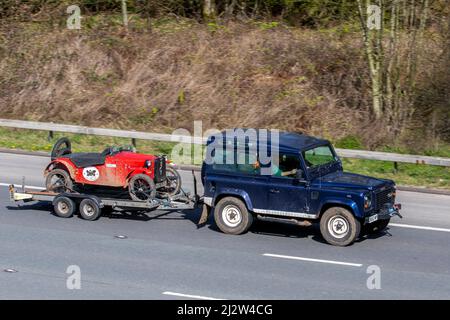 2019 Manx Classic rot Austin 7 wird von 2003 blauen Land Rover Defender 90 TD5 X SWB auf der M6 Motorway UK abgeschleppt Stockfoto