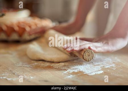 Mach dich auf den Weg. Zugeschnittenes Bild einer Reihe von Händen, die den Teig ausrollen. Stockfoto