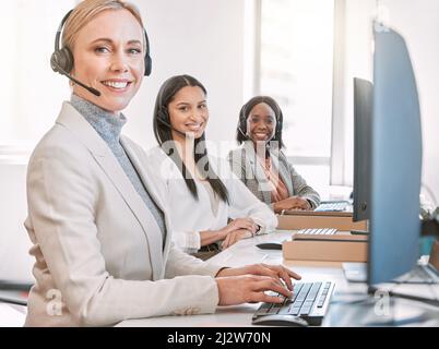 Wir haben alle Antworten erhalten. Beschnittenes Porträt einer attraktiven reifen Callcenter-Agenten, die ein Headset trägt, während sie mit ihr im Büro arbeitet Stockfoto
