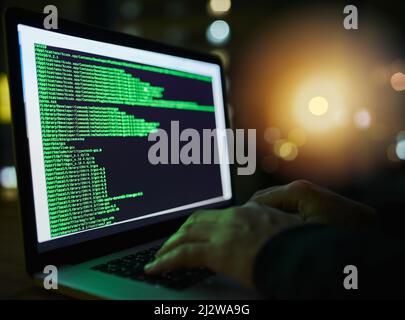 Tun Sie Ihr Bestes, um Ihre Daten zu schützen. Aufnahme eines nicht erkennbaren Computerhackers, der spät in der Nacht einen Laptop benutzt. Stockfoto